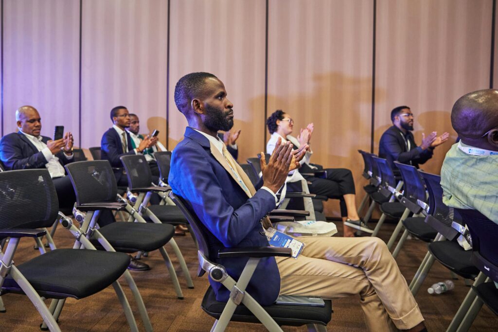 Diverse group clapping during a business conference with focus on engaged participation.